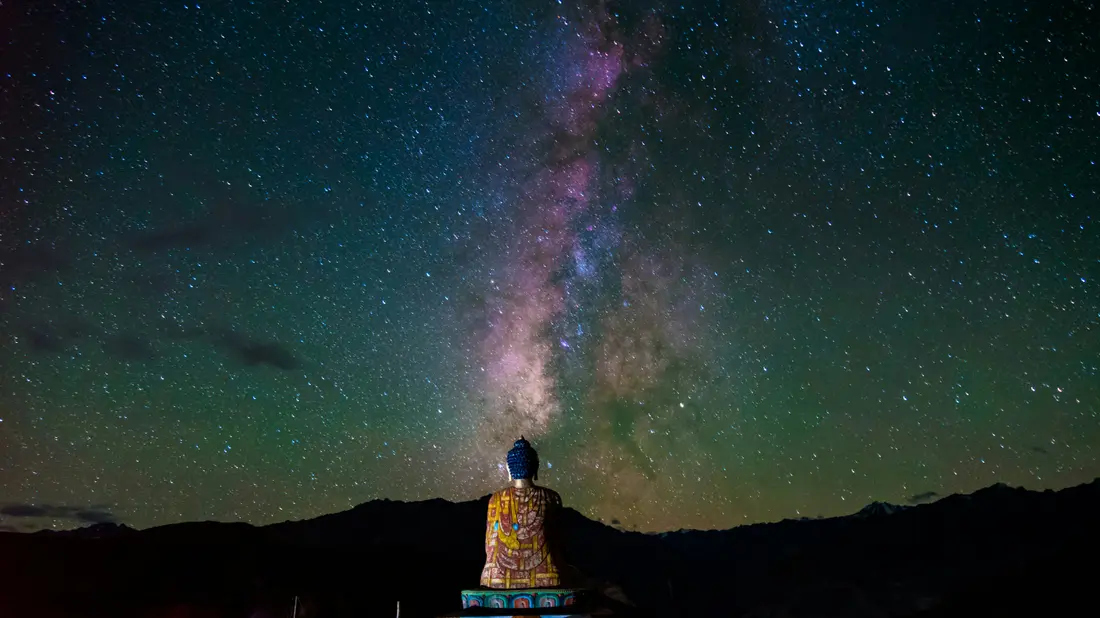 The Milky Way over a Buddha statue silhouette in Spiti at night
