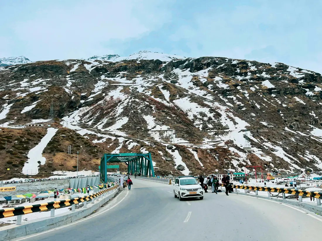 A mountain road bridge crossing a river in the snow
