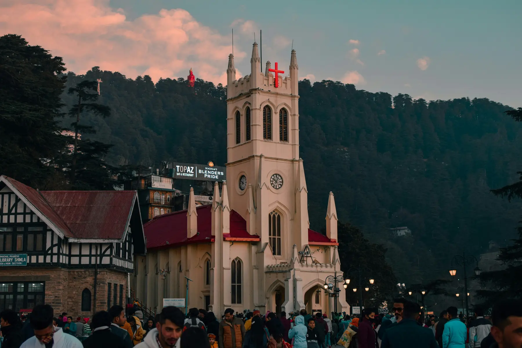 Christ Church lit at dusk on the Ridge in Shimla, with crowds gathered below